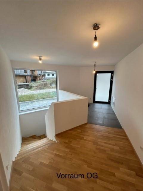 Heller Vorraum im Obergeschoss mit Holzparkettboden und Blick nach draußen.
