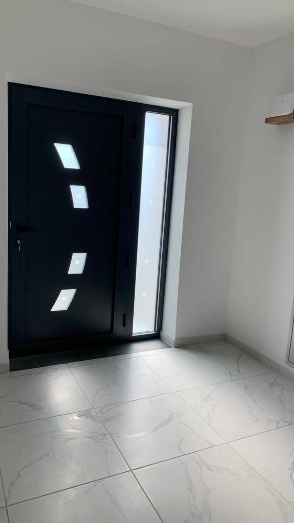 Moderne schwarze Eingangstür mit Glaseinsätzen und hellem Fliesenboden.
