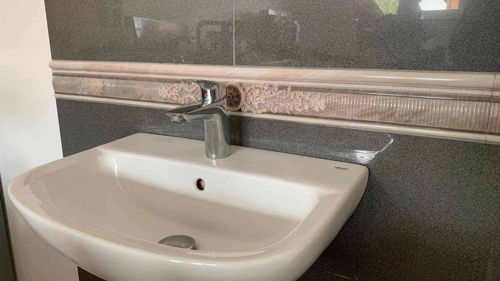 Modernes Waschbecken mit Chromarmatur und dekorativen Fliesen im Badezimmer.
