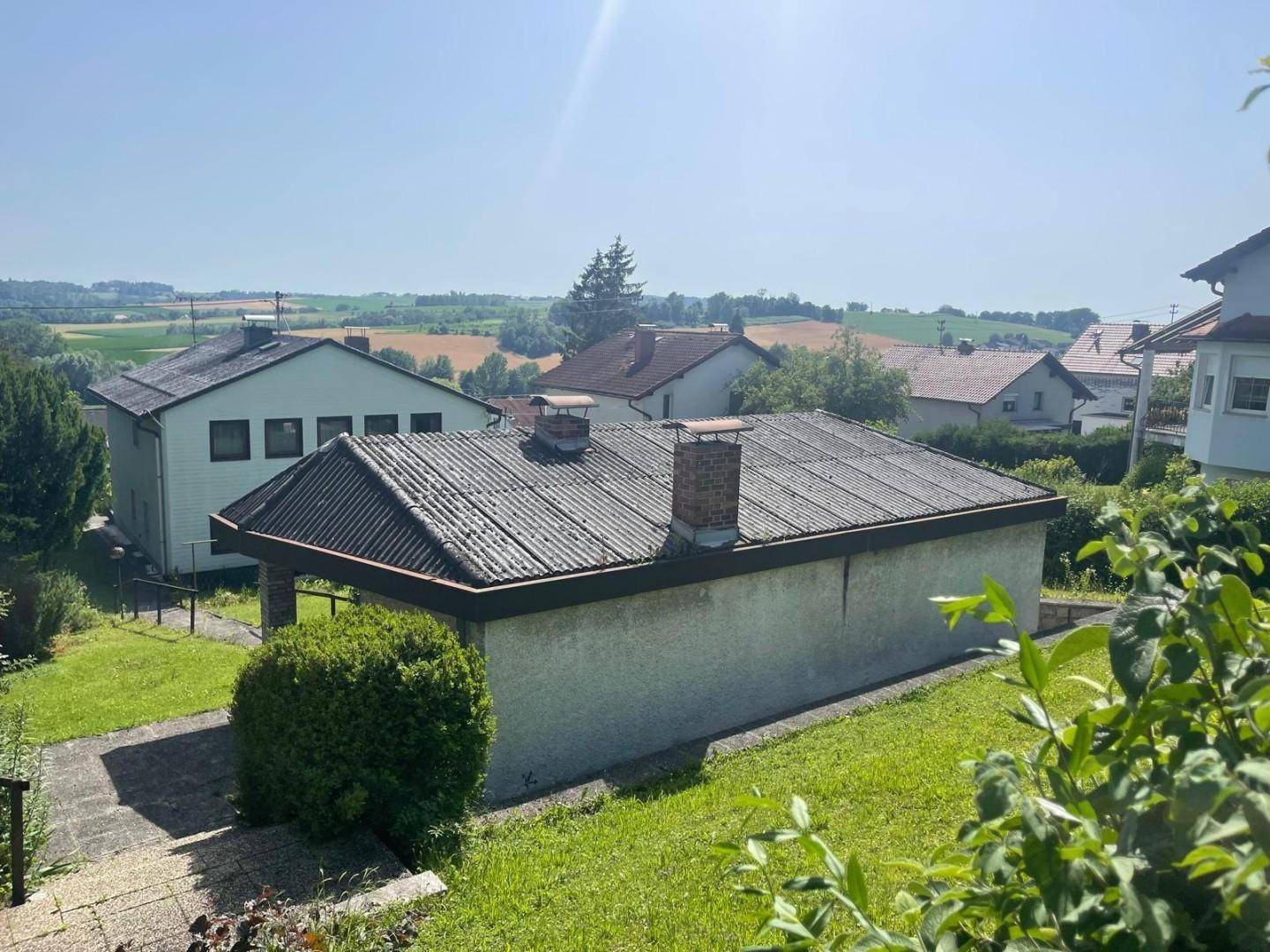 Sonniger Gartenbereich mit Blick auf die ländliche Umgebung und Nachbarhäuser.