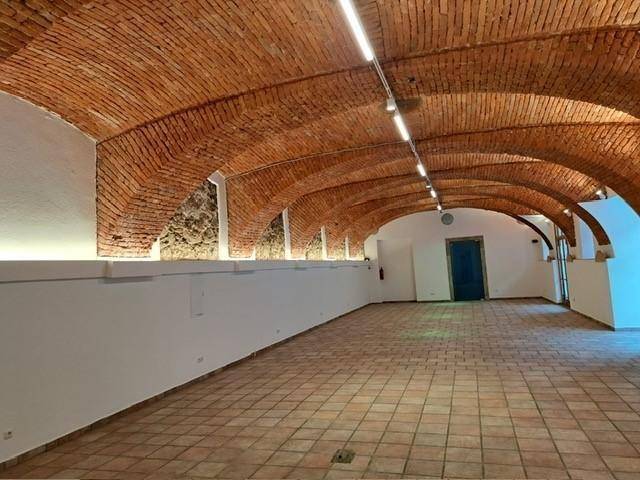 Historischer Raum mit beeindruckendem Gewölbe aus Ziegelsteinen und Terrakotta-Fliesenboden.