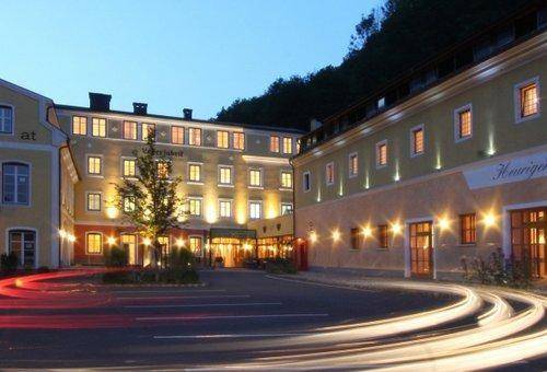Beleuchtete Gebäudefassade bei Nacht, zeigt ein historisches Gebäude mit vielen Fenstern.