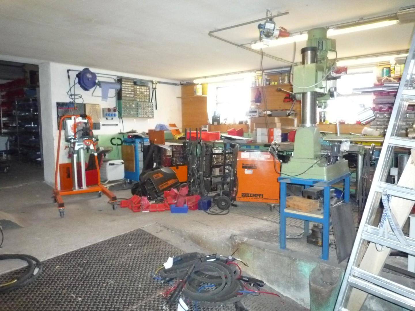Werkstattraum mit verschiedenen Maschinen, Werkzeugen und Lagerregalen.