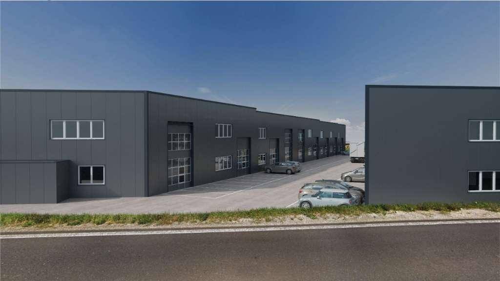 Nahaufnahme der modernen Gewerbeimmobilie mit dunkler Fassade, großen Fenstern und angrenzenden Parkplätzen.