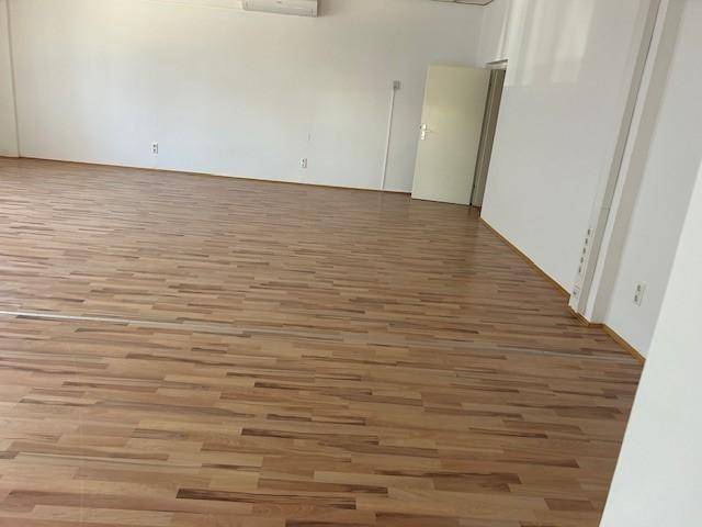 Heller Raum mit glänzendem Holzboden und weißen Wänden, bereit für die Einrichtung.