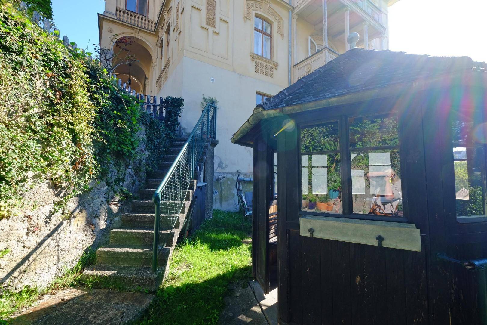Außentreppe führt zu einem kleinen Gartenhaus neben der historischen Villa.