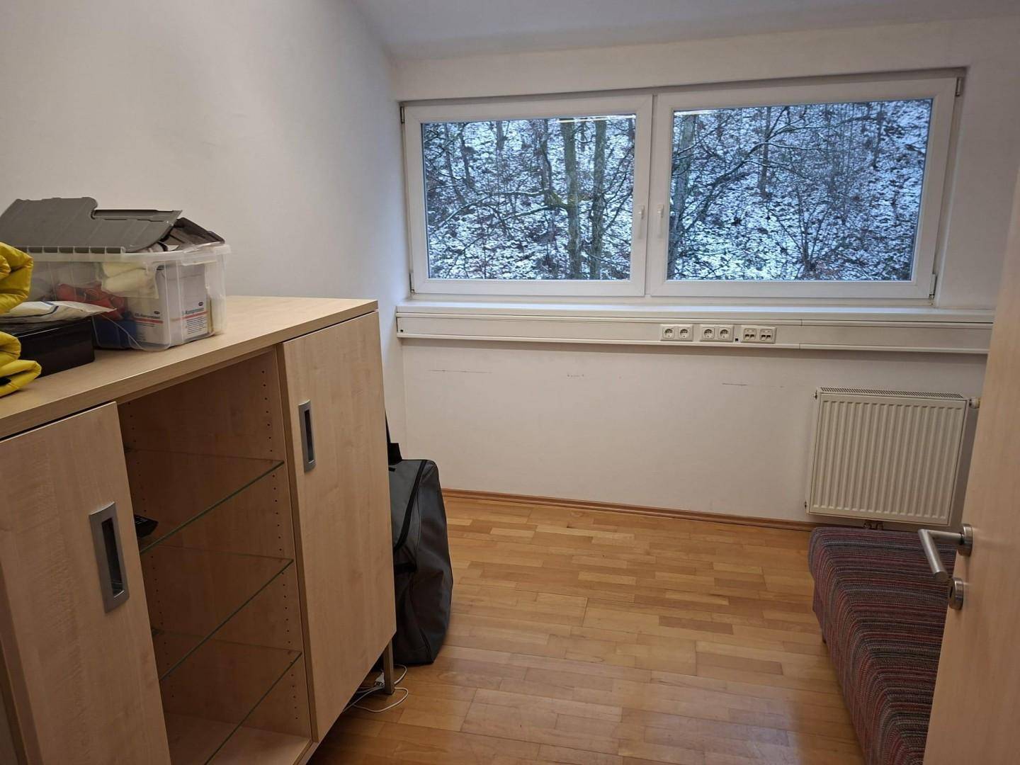 Kleiner Pausenraum mit Fenster, Schrank und einer Liege, ideal für kurze Erholungspausen.