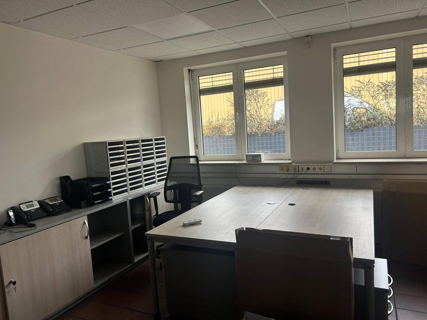 Helles Büro mit zwei Fenstern, einem großen Schreibtisch und Büromöbeln, bereit zur Nutzung und gut gepflegt.