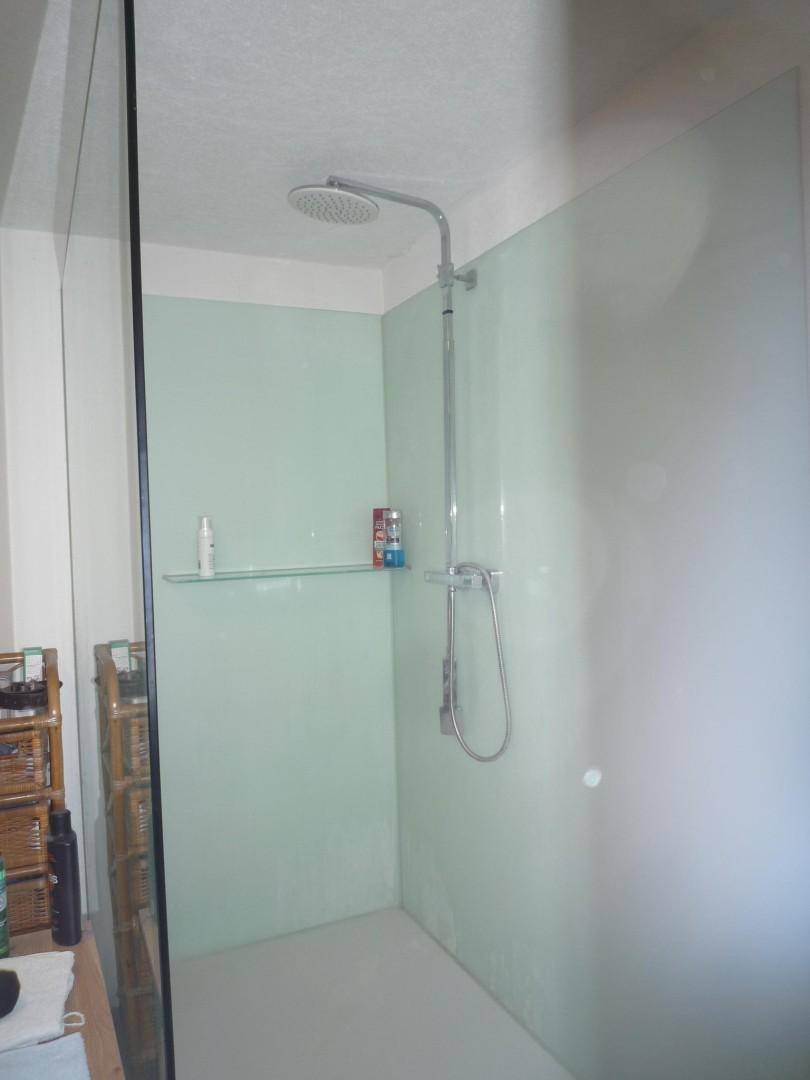 Moderne Duschkabine mit Regendusche und minimalistischem Design in hellem Grün.