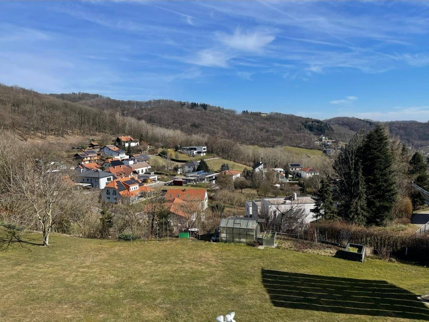 Panoramablick auf die umliegende Hügellandschaft und ein Dorf im Tal.