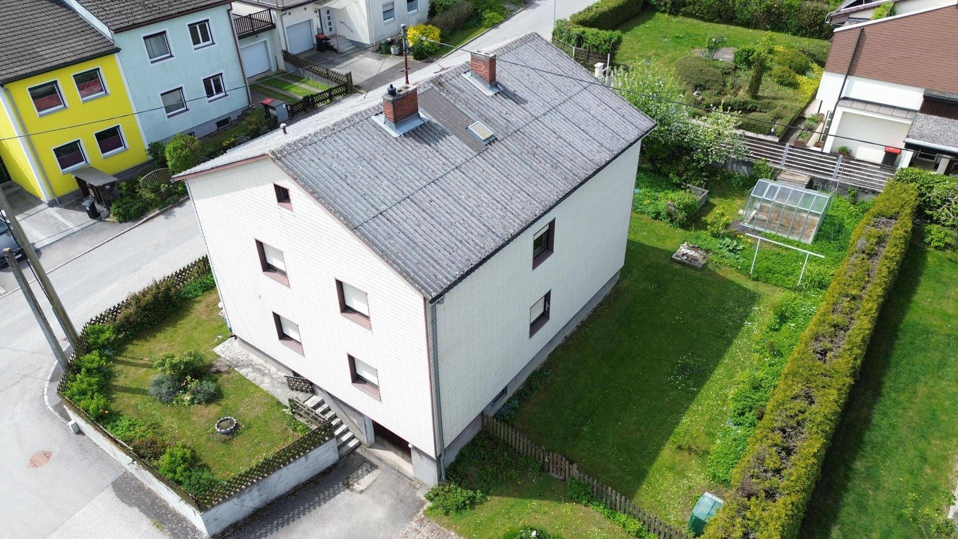 Ansicht des Hauses von oben mit Garten, Gewächshaus und Nachbarhäusern.