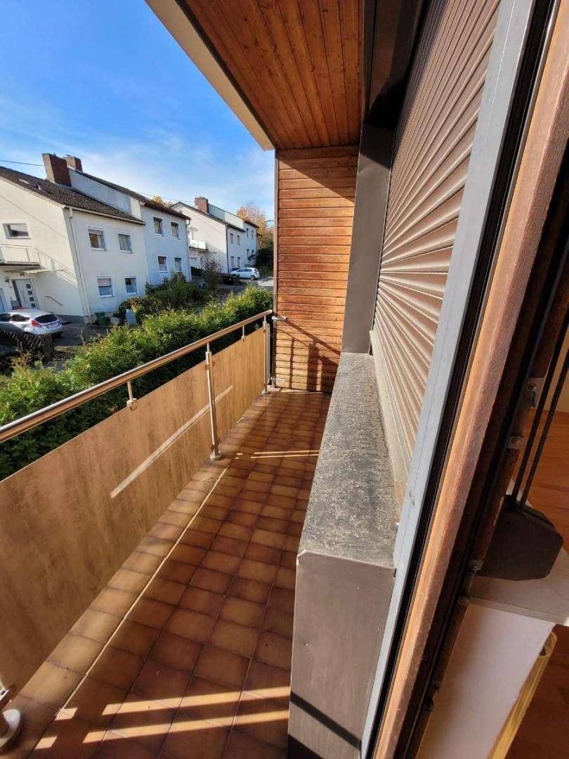 Balkon mit Fliesenboden, Holzverkleidung und Blick auf die Nachbarschaft.