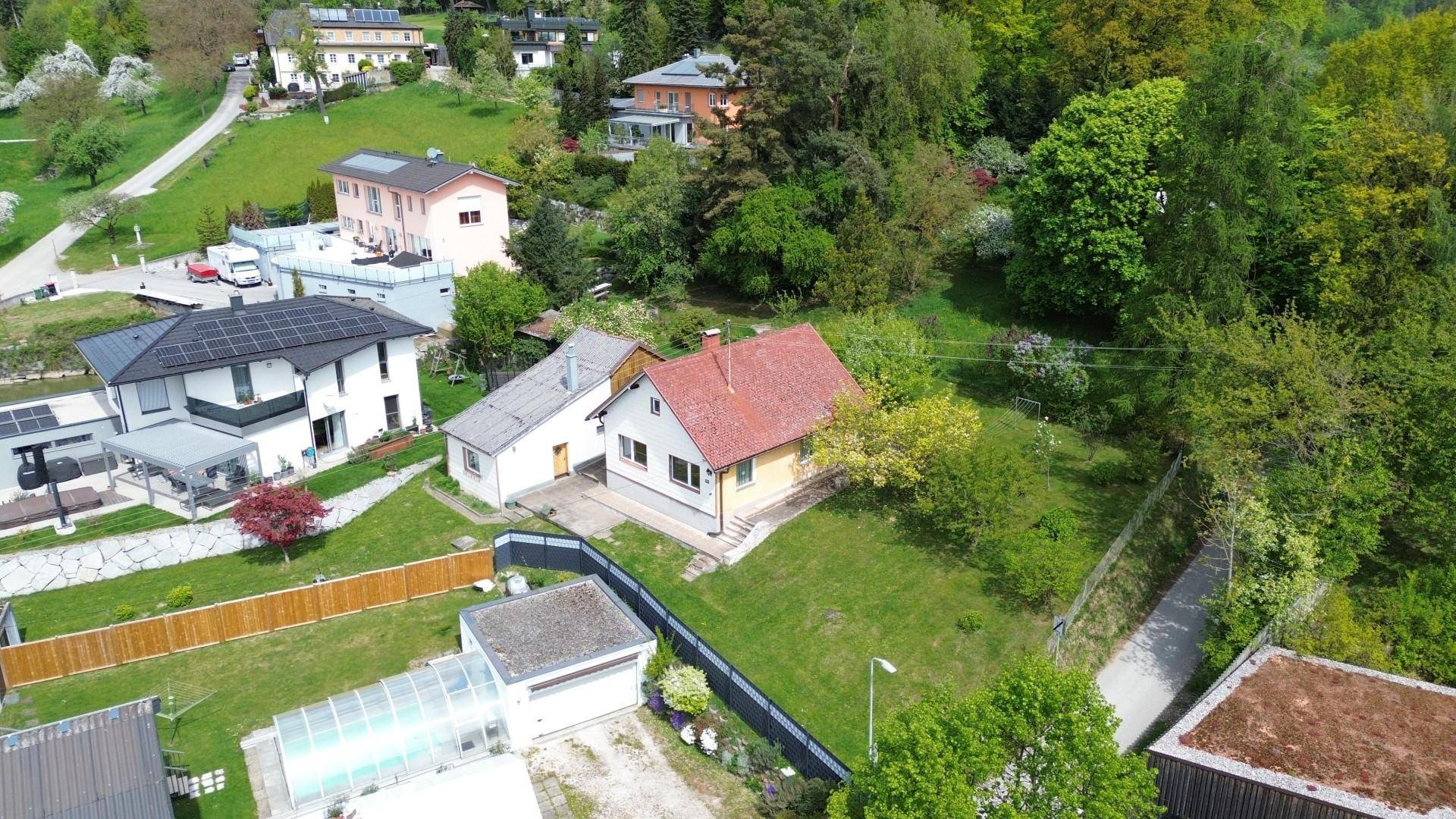 Panoramablick aus der Luft auf das Wohnhaus in einer grünen Wohngegend mit Hügellandschaft.