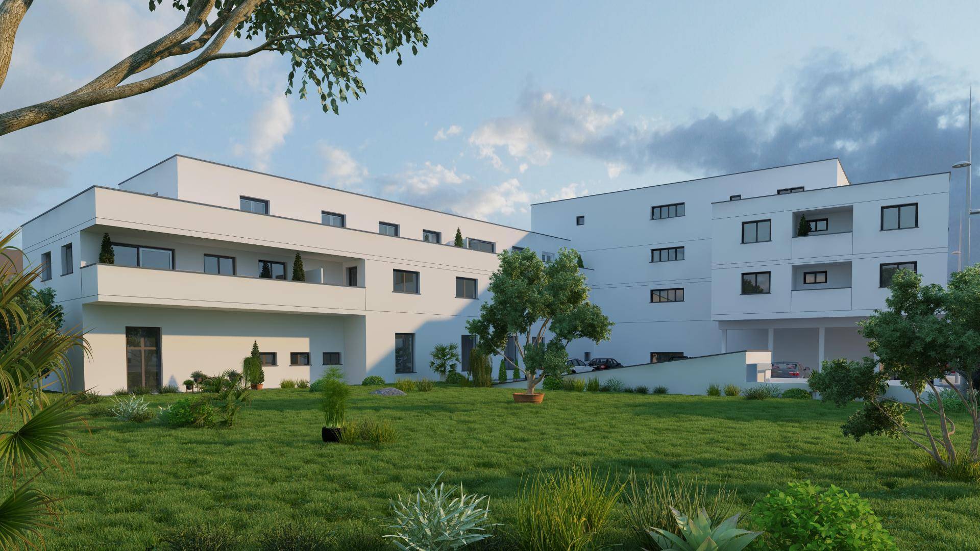 Grüne Gartenanlage mit Bäumen und Sträuchern im Innenhof eines modernen Wohngebäudes.