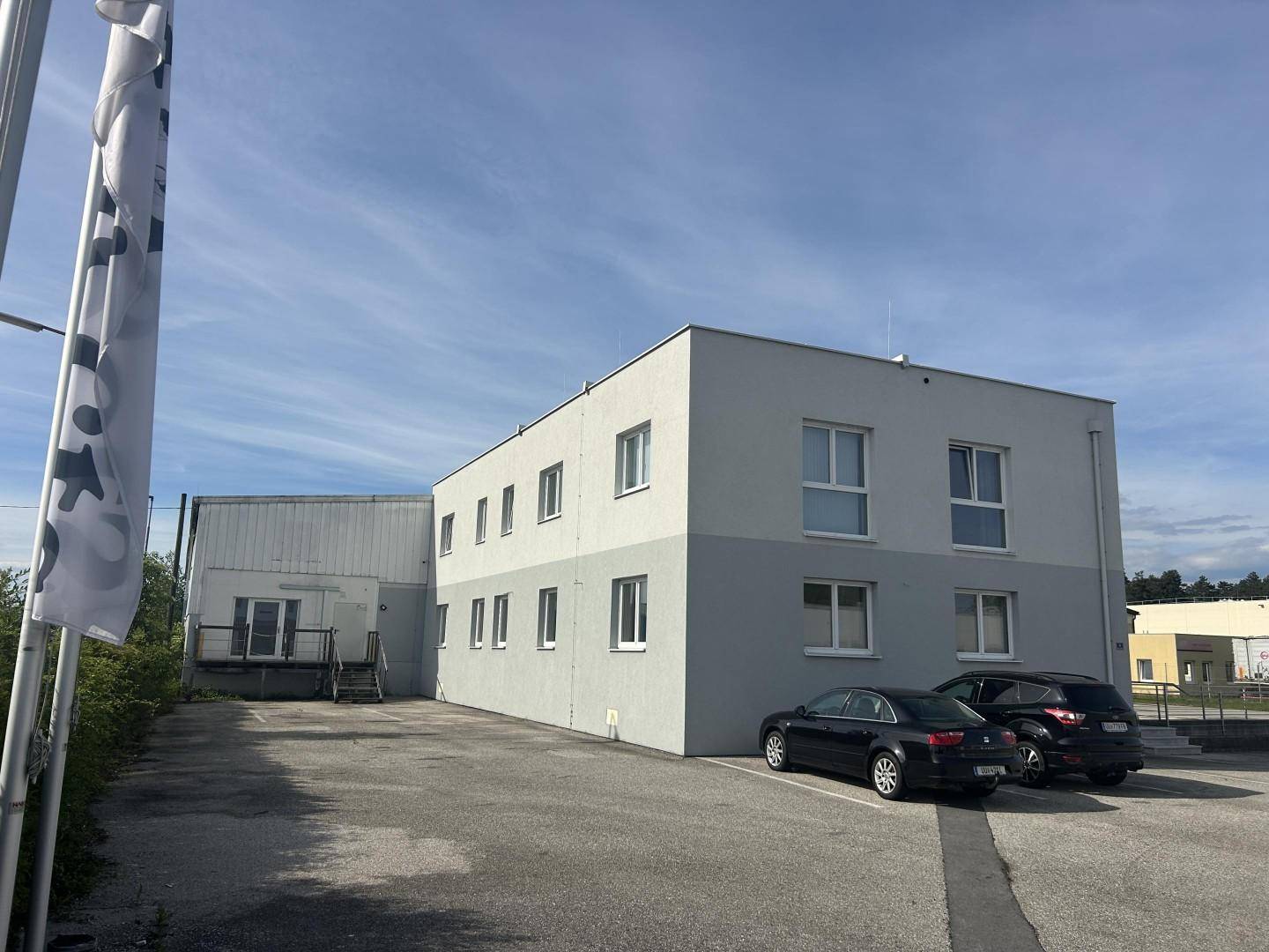 Seitenansicht des Bürogebäudes mit angrenzendem Bereich und weiteren Parkmöglichkeiten auf dem Gelände.
