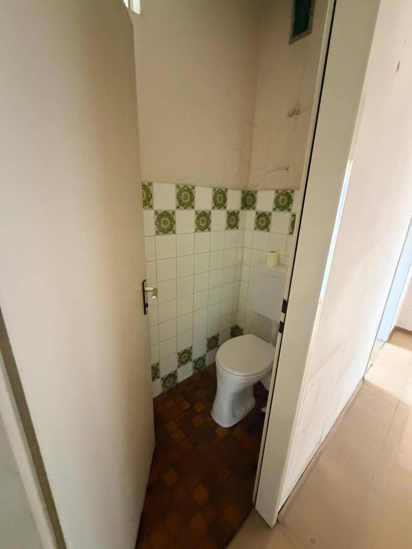 Separate Gästetoilette mit WC, Fliesen im Retro-Stil und Terrakotta-Boden.