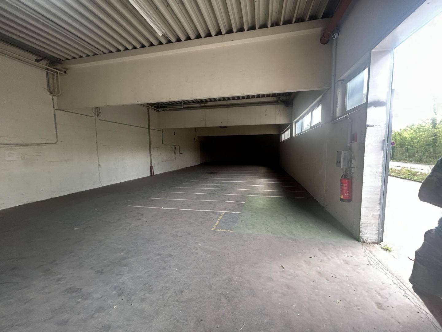 Leere Tiefgarage mit Betonboden und Deckenbeleuchtung, bereit zur Nutzung.