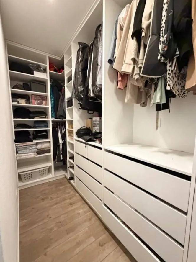 Geräumiger begehbarer Kleiderschrank mit maßgefertigten Regalen und Schubladen.