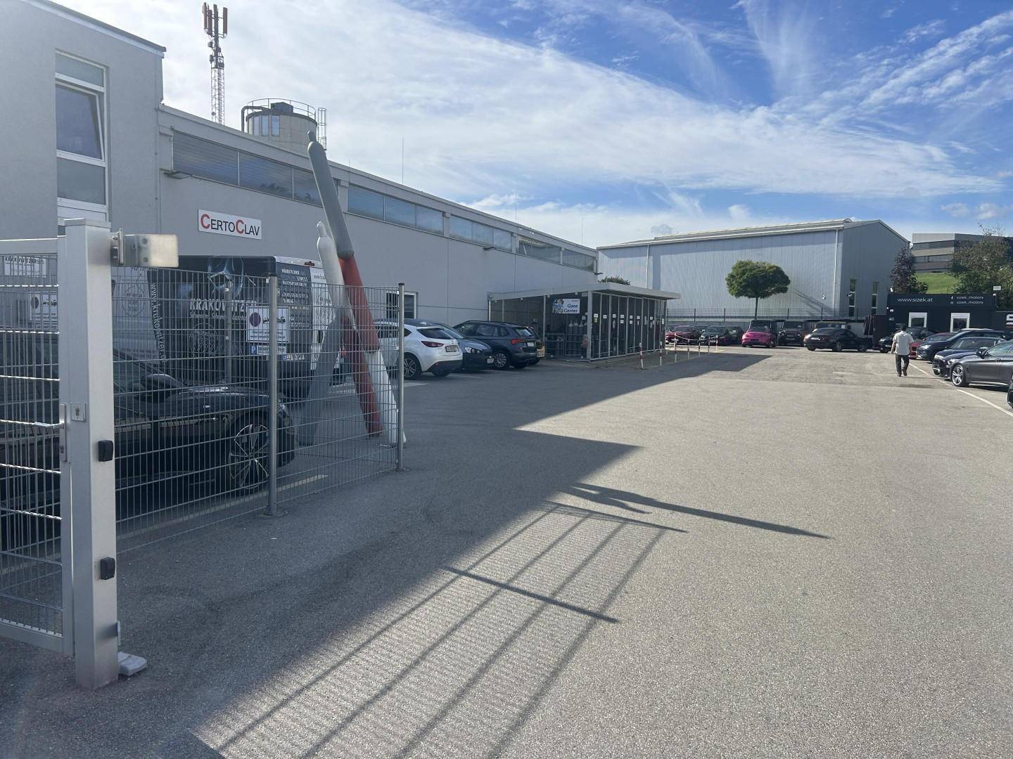 Gewerbegebäude mit großem Parkplatz und einem markanten Propeller-Kunstwerk am Eingangsbereich.