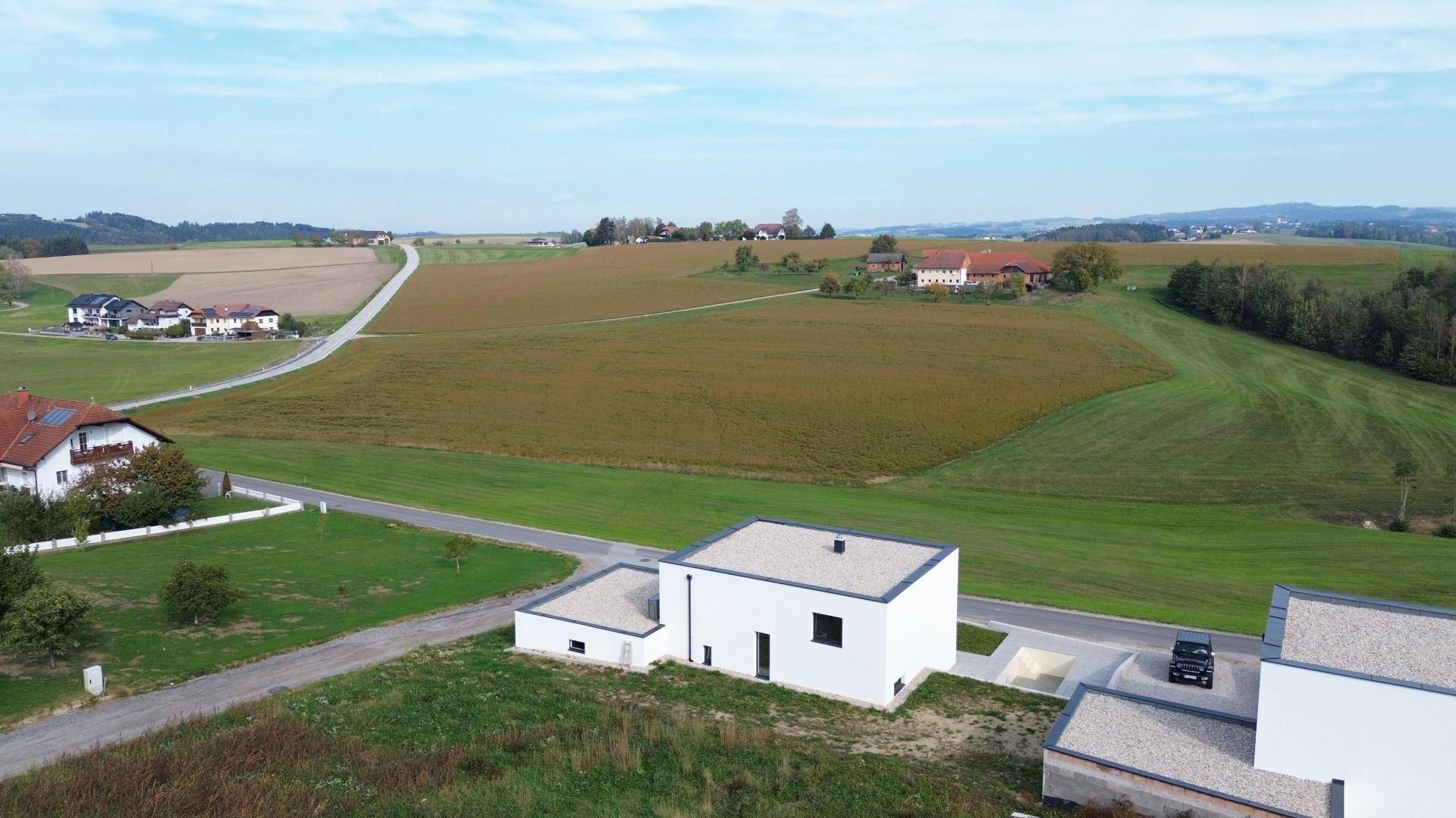 Luftaufnahme eines modernen Hauses mit Flachdach und weitem Blick über die ländliche Umgebung.