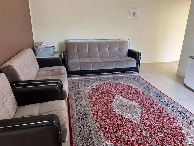 Gemütlicher Wohnbereich mit zwei Sofas und einem großen, farbenfrohen Orientteppich auf hellem Boden.