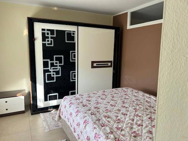 Schlafzimmer mit Doppelbett und einem großen Schiebetürenschrank mit modernem geometrischem Muster.