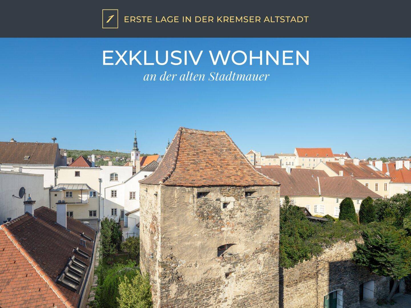 Historischer Turm in der Kremser Altstadt, umgeben von traditionellen Gebäuden unter blauem Himmel.