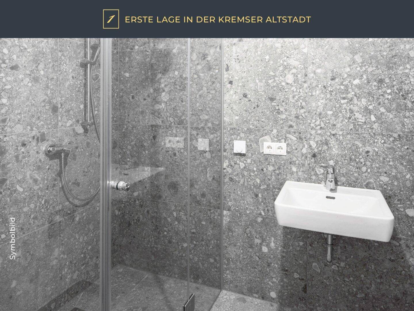 Modernes Badezimmer mit grauen Terrazzo-Fliesen, ebenerdiger Dusche und minimalistischem Waschbecken.