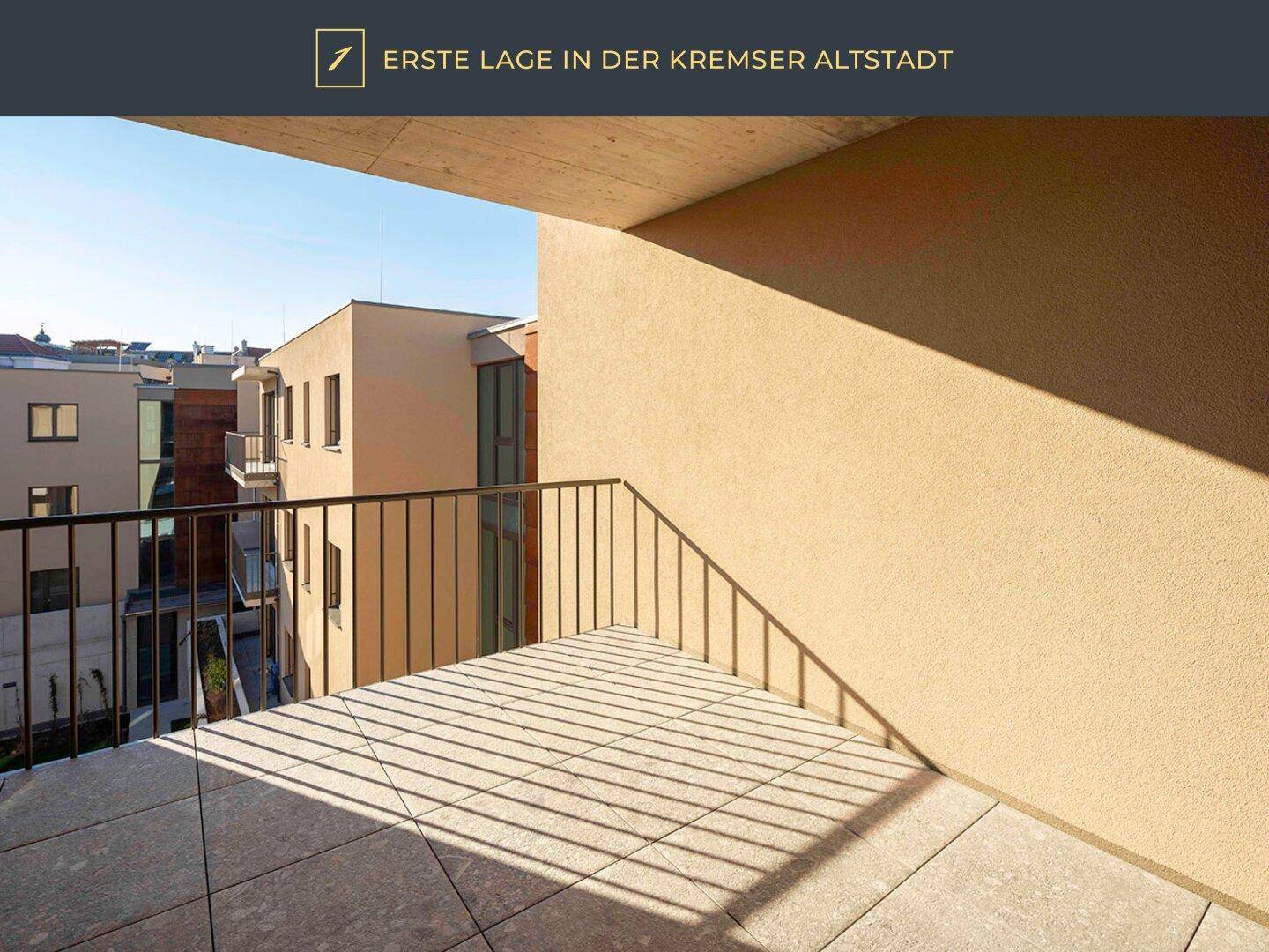 Sonniger Balkon mit Fliesenboden und Blick auf die moderne Architektur des Gebäudes.