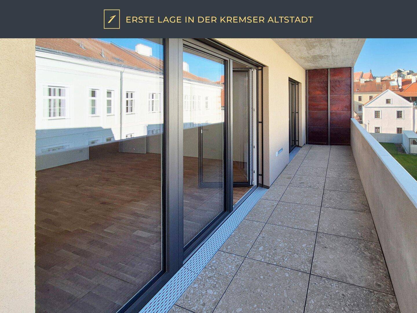 Langer Balkon mit Fliesenboden und großen Schiebetüren zum Innenraum.