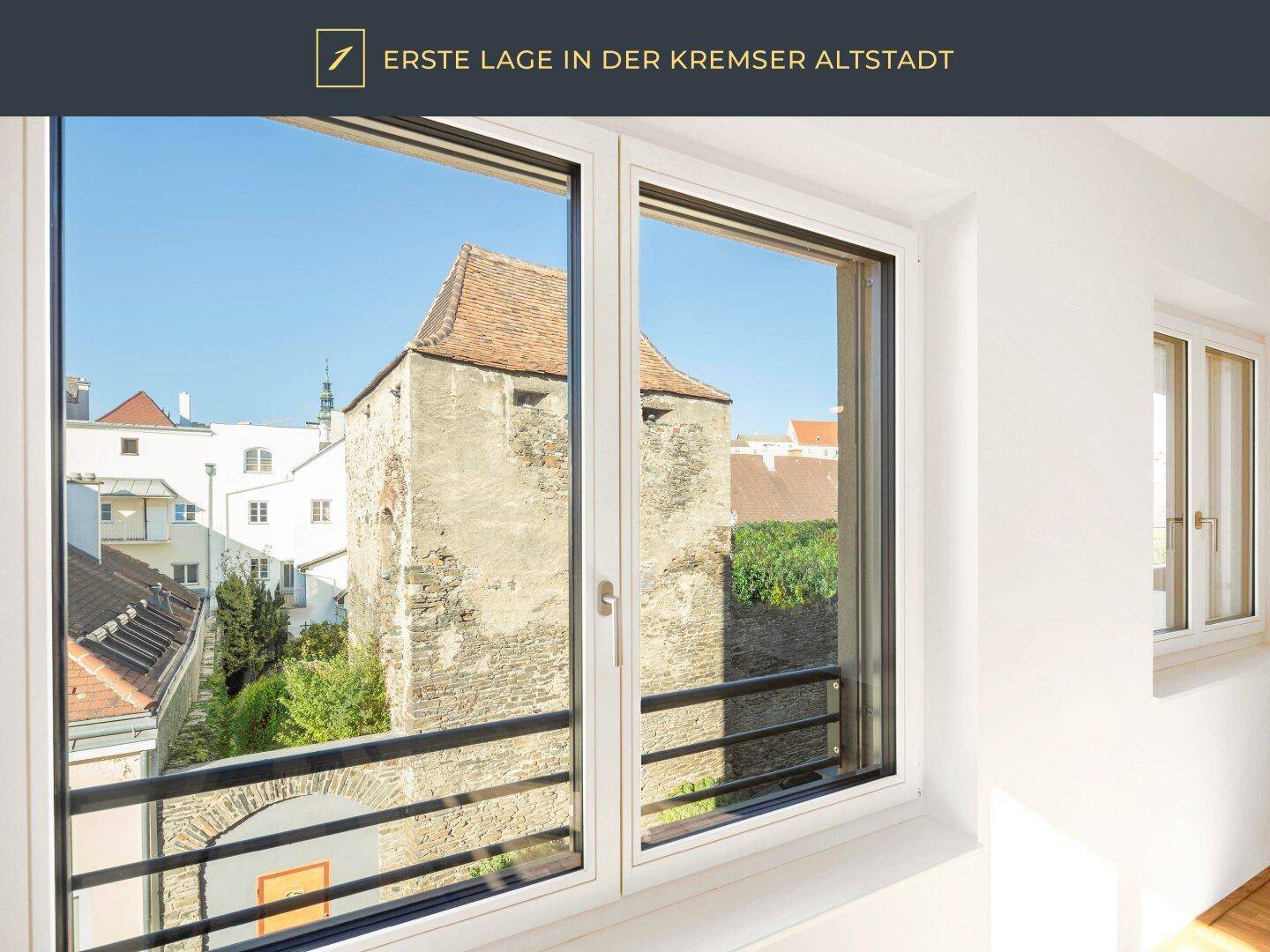 Fenster mit Blick auf einen historischen Turm und die Dächer der Altstadt.