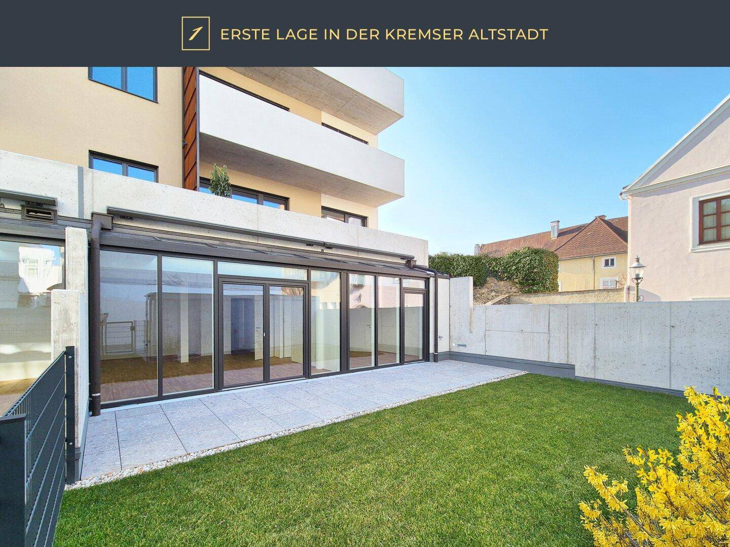Moderne Terrasse mit Rasenfläche und Blick auf die umliegenden Gebäude.
