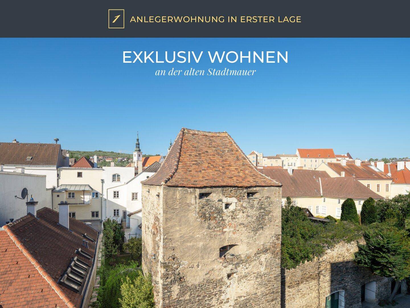 Historische Stadtansicht mit alter Stadtmauer und Turm, umgeben von traditionellen Gebäuden.