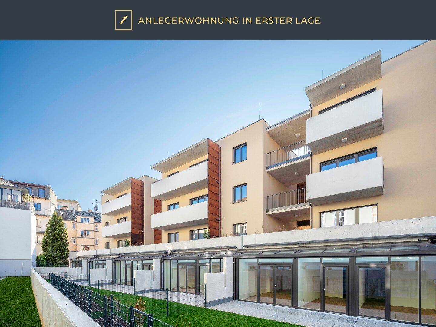 Moderne Fassade eines Neubaus mit Balkonen und großen Glasfronten im Erdgeschossbereich.