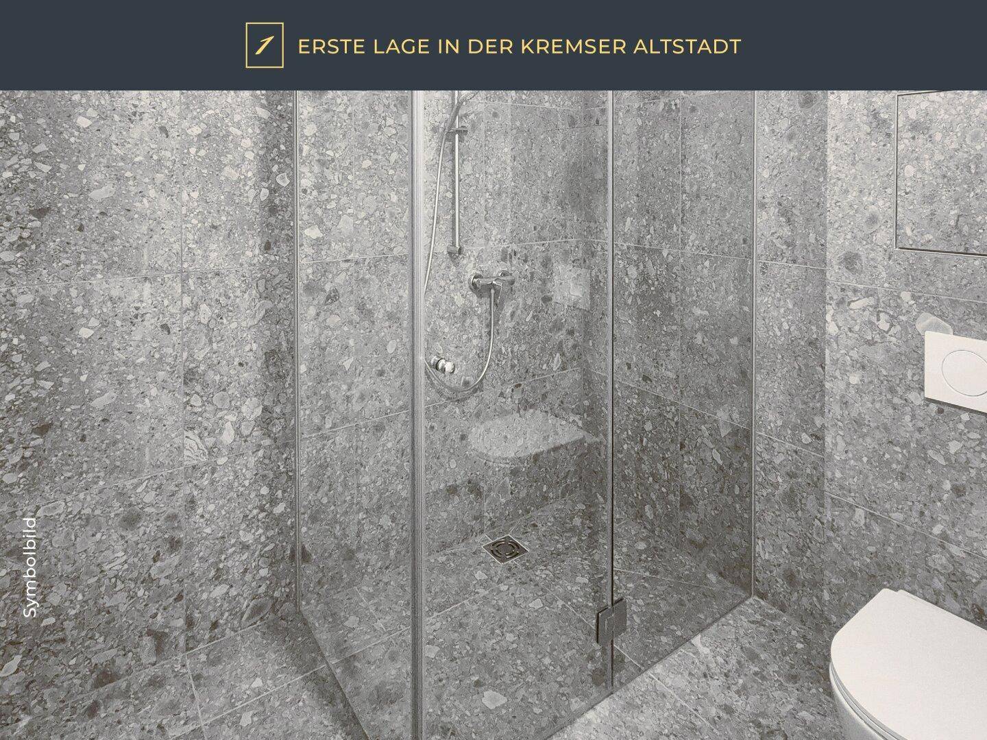 Modernes Badezimmer mit großformatigen grauen Fliesen und einer geräumigen begehbaren Dusche.