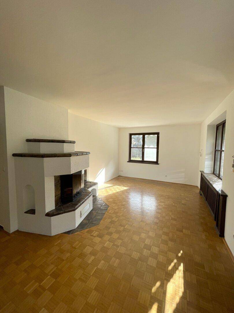 Helles Wohnzimmer mit traditionellem Kamin und Parkettboden.