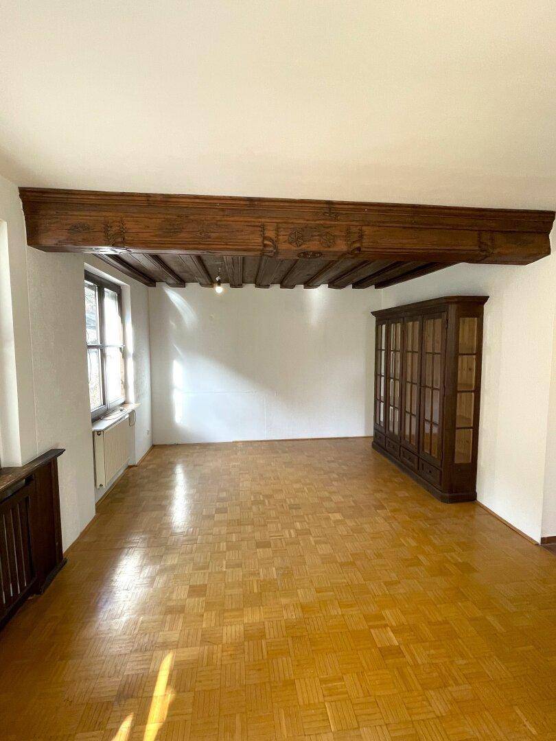 Heller Raum mit Holzbalkendecke und Parkettboden, ideal für individuelle Gestaltung.