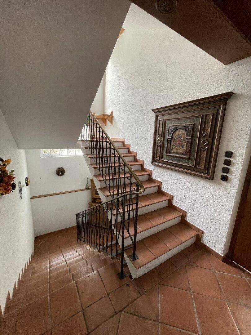 Geräumiges Treppenhaus mit Terrakottafliesen und dekorativer Wandgestaltung.