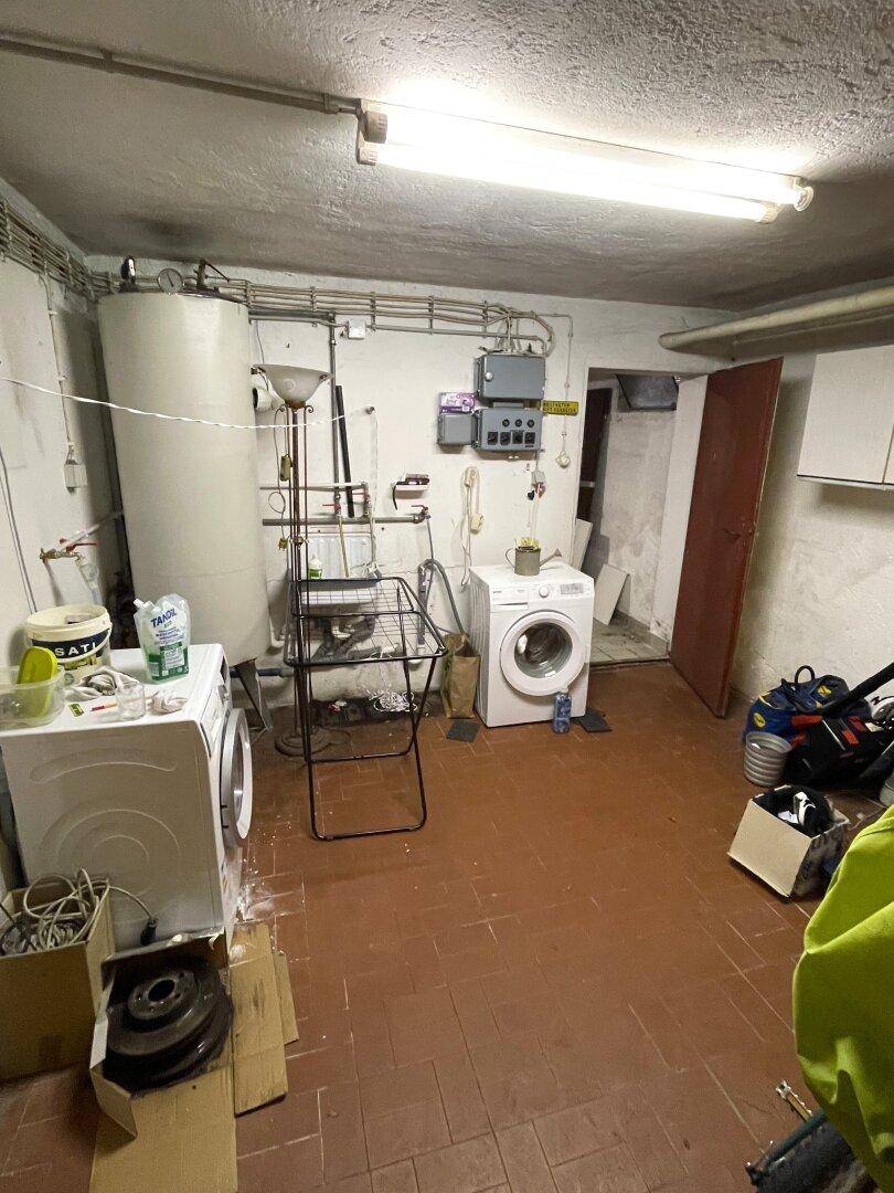 Waschküche im Keller mit Waschmaschinen und Warmwasserboiler.