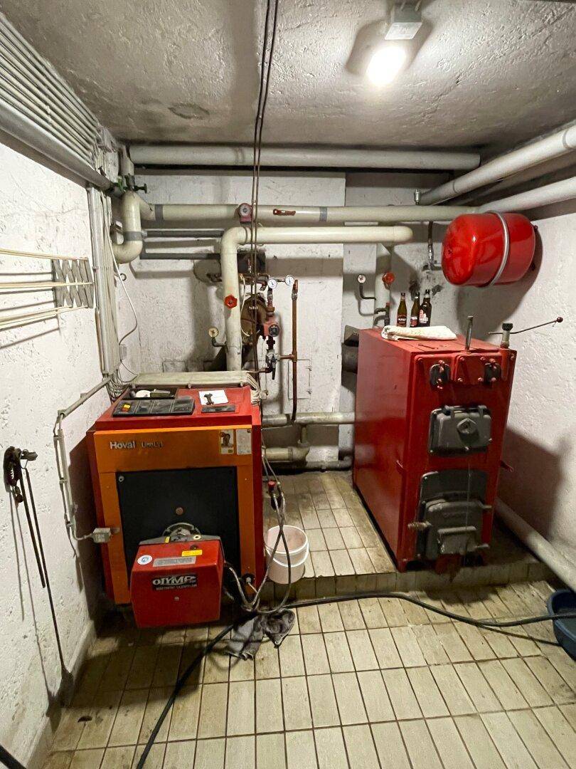 Heizraum im Keller mit zwei Heizkesseln und Rohrleitungen.