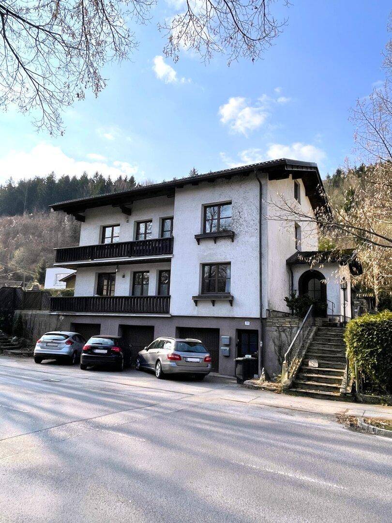 Ansicht des Wohnhauses mit Balkonen und geparkten Autos vor der Garage.