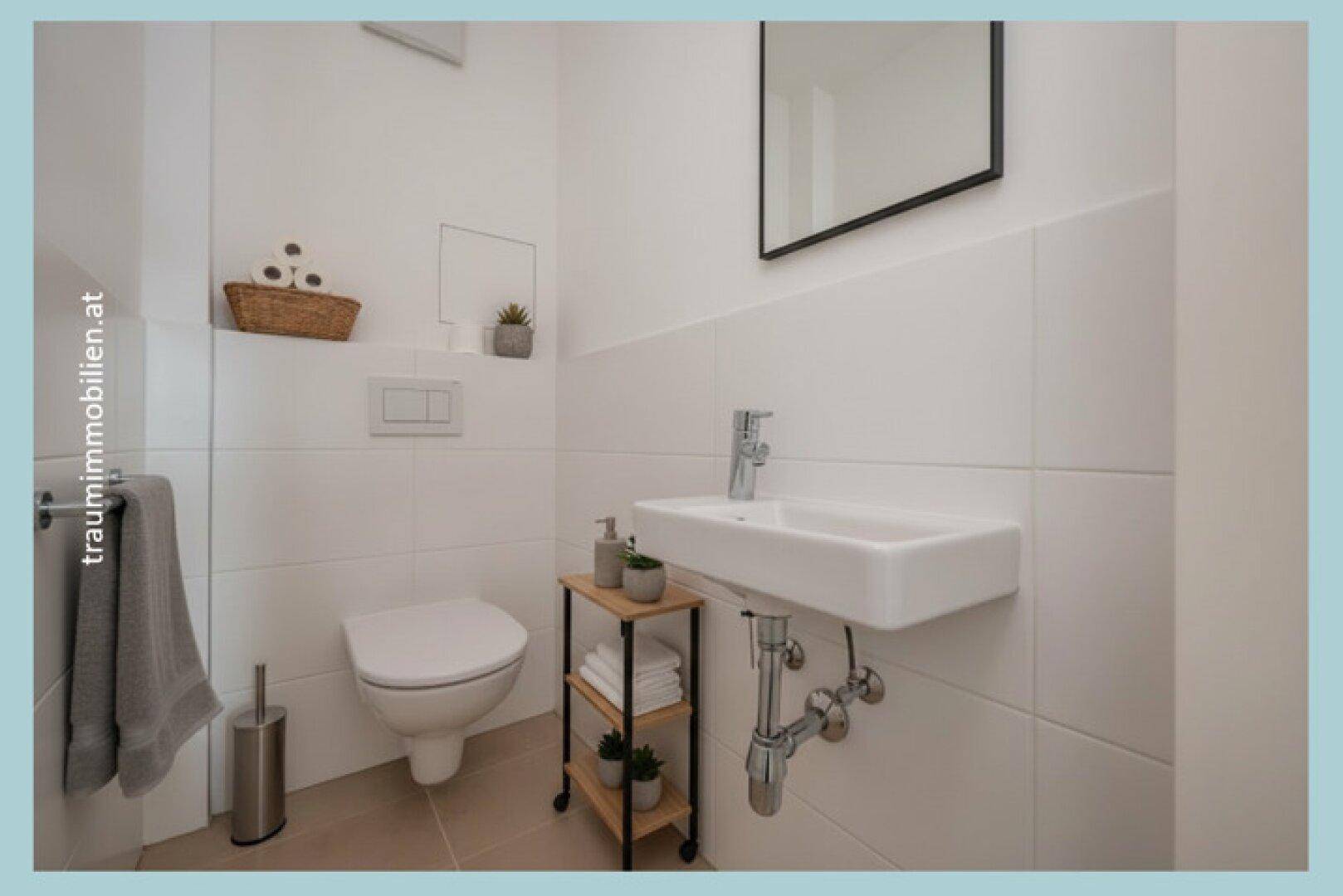Modernes Gäste-WC mit wandhängender Toilette und kleinem Waschbecken.