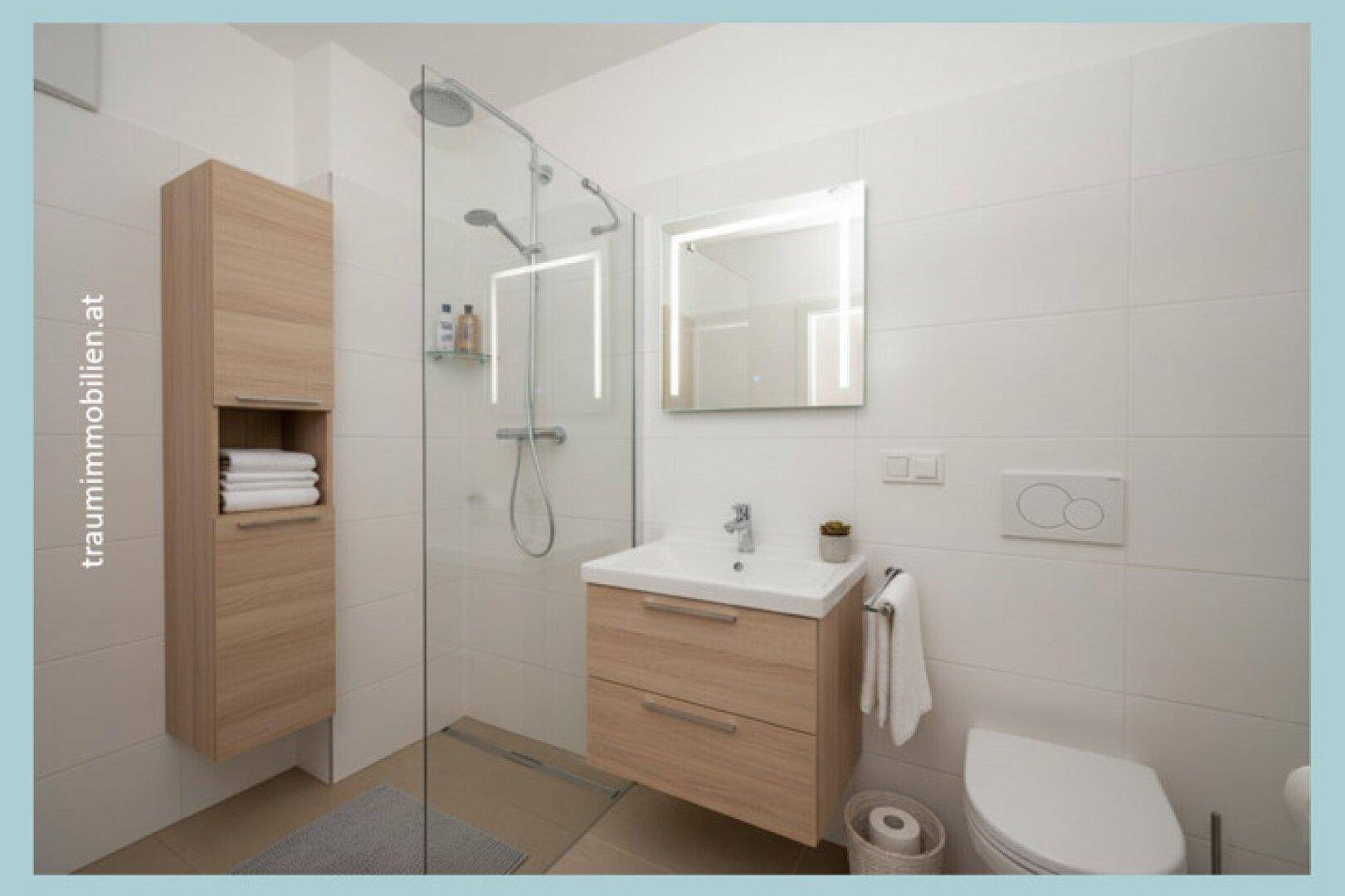 Modernes Badezimmer mit ebenerdiger Dusche, Waschtisch und hellen Fliesen.