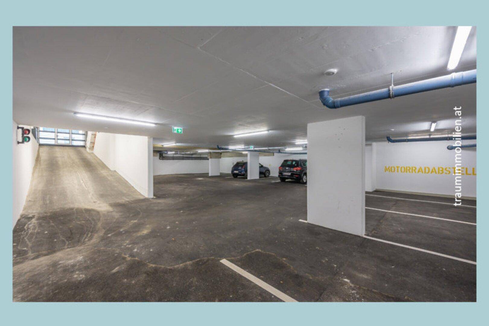 Zufahrt und Stellplätze in einer modernen Tiefgarage mit guter Beleuchtung.