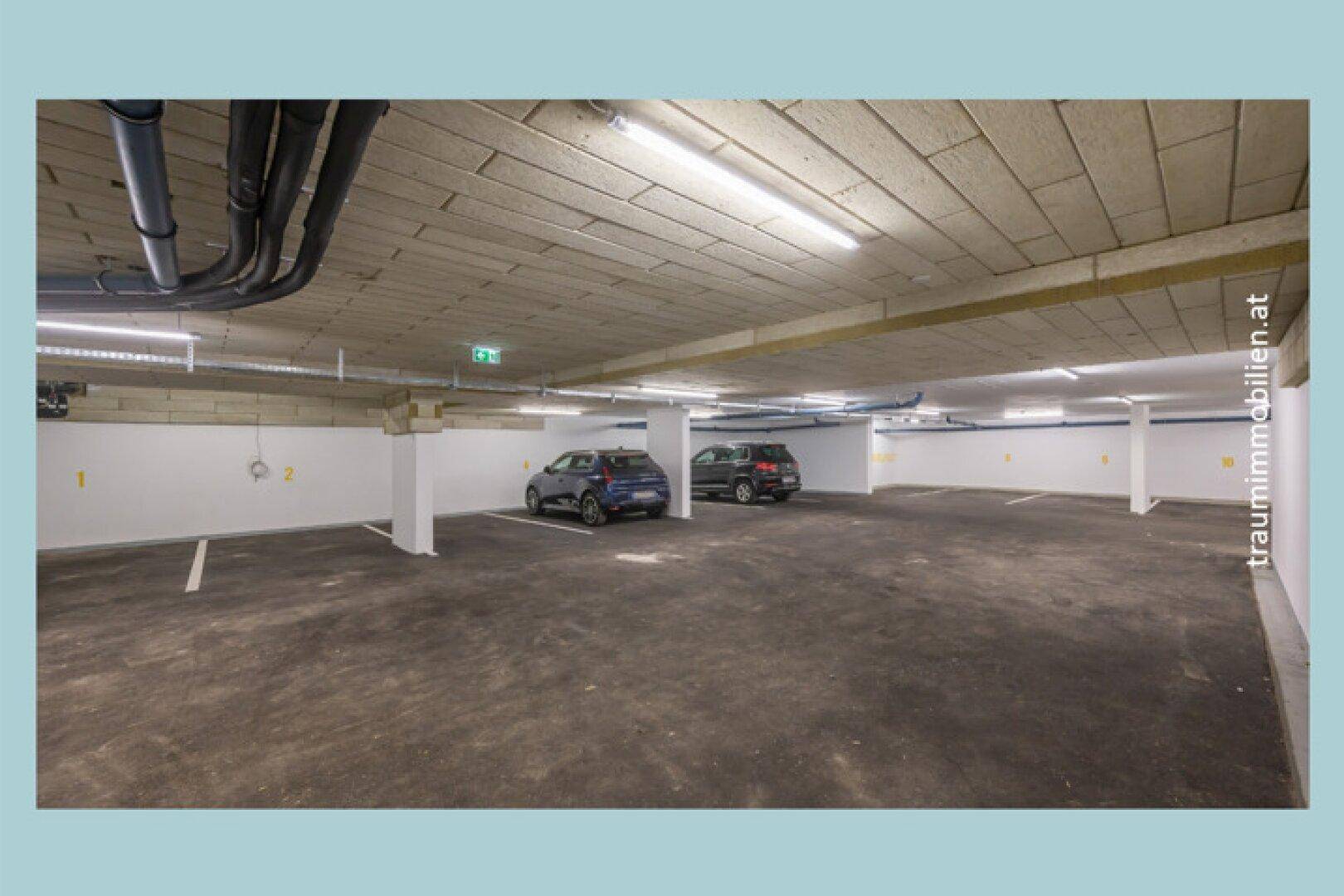 Helle Tiefgarage mit markierten Parkplätzen und guter Beleuchtung.