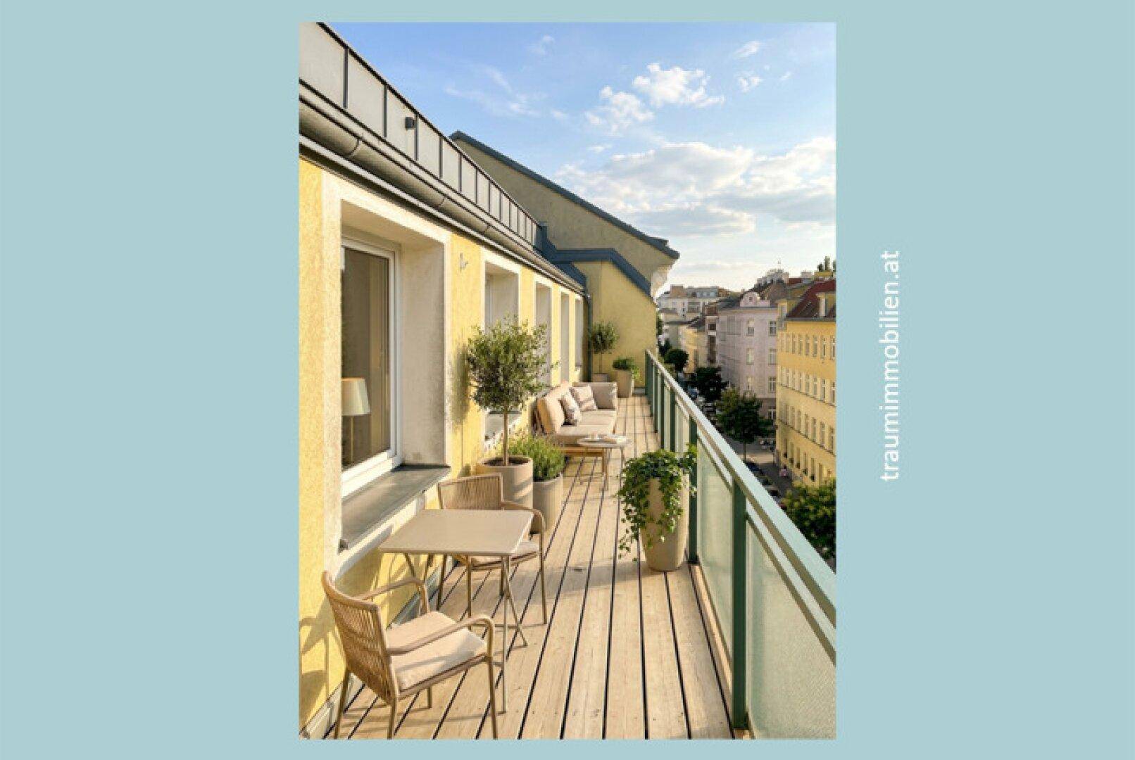 Sonniger Balkon mit Holzboden, gemütlichen Möbeln und weitem Stadtblick.