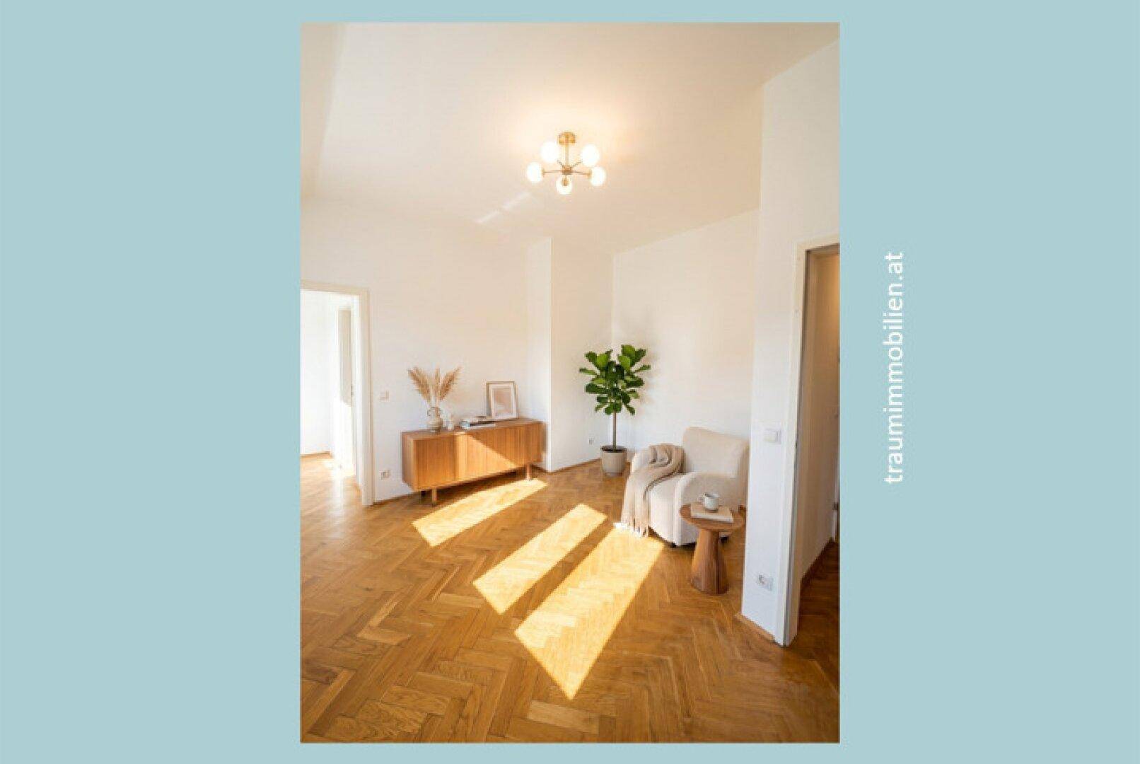 Heller Flur mit Fischgrätparkett, modernem Sideboard und viel natürlichem Licht.