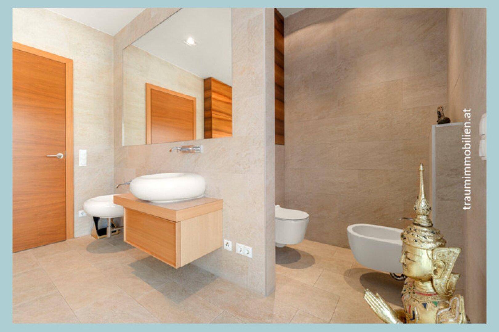 Modernes Badezimmer mit schwebendem Waschtisch, runder Spüle und beigefarbenen Fliesen.