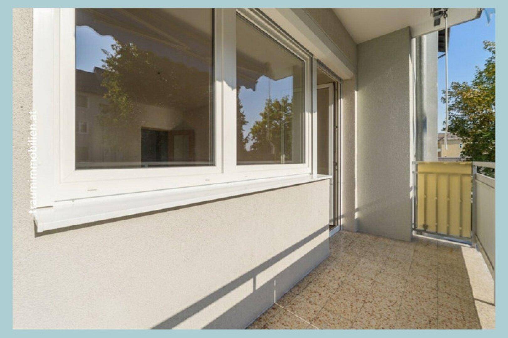 Detailansicht eines Fensters und des Balkons mit Blick auf die Umgebung.