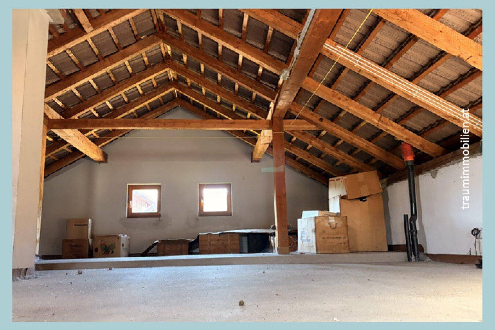 Unausgebauter Dachboden mit sichtbaren Holzbalken und Ausbaupotenzial.